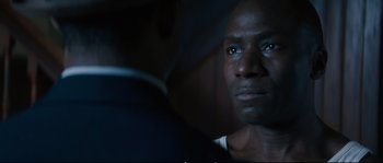Movie still from “Race” (2016), directed by Stephen Hopkins – A person looking at the camera; Close Up shot, Over the shoulder angle
