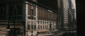 Movie still from “Race” (2016), directed by Stephen Hopkins – A large building with many flags on the side of the building; Extreme Wide shot, High angle