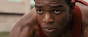 Movie still from “Race” (2016), directed by Stephen Hopkins – A person looking at the camera; Close Up shot, High angle
