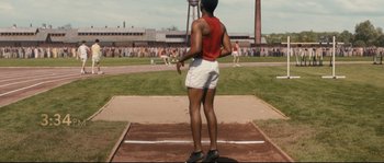 Movie still from “Race” (2016), directed by Stephen Hopkins – A man standing on a track in front of a crowd; Wide shot, High angle