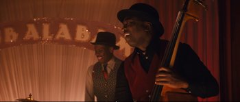 Movie still from “Race” (2016), directed by Stephen Hopkins – Two men in suits and hats are playing a musical instrument; Medium shot, Low angle