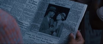 Movie still from “Race” (2016), directed by Stephen Hopkins – An old photo of a man and a woman in a newspaper; Extreme Close Up shot, Overhead angle