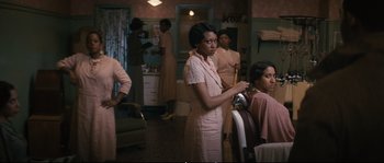 Movie still from “Race” (2016), directed by Stephen Hopkins – A group of women standing in a room; Medium shot, Over the shoulder angle