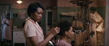 Movie still from “Race” (2016), directed by Stephen Hopkins – A woman is getting her hair cut by another woman; Close Up shot, Over the shoulder angle