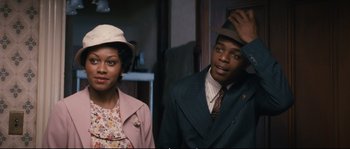 Movie still from “Race” (2016), directed by Stephen Hopkins – A man and a woman standing next to each other; Medium shot, Over the shoulder angle