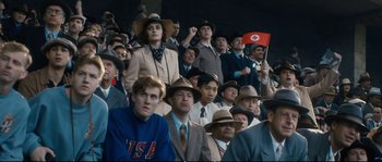 Movie still from “Race” (2016), directed by Stephen Hopkins – A group of people wearing hats and suits in a crowd; Medium shot, High angle