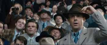 Movie still from “Race” (2016), directed by Stephen Hopkins – A crowd of people wearing hats and suits; Close Up shot, Low angle