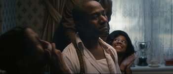 Movie still from “Race” (2016), directed by Stephen Hopkins – A black man with his mouth open and his eyes wide open; Close Up shot, Over the shoulder angle