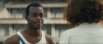 Movie still from “Race” (2016), directed by Stephen Hopkins – A man in a white shirt is talking to a woman; Close Up shot, Over the shoulder angle