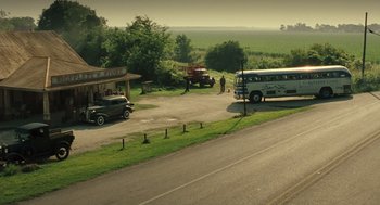 Movie still from “Ray” (2004), directed by Taylor Hackford – An old bus is parked on the side of the road; Extreme Wide shot, High angle