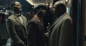 Movie still from “Ray” (2004), directed by Taylor Hackford – A group of men standing next to each other on a train; Medium shot, Low angle