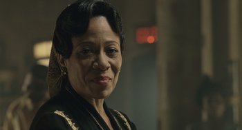 An older woman is smiling for the camera