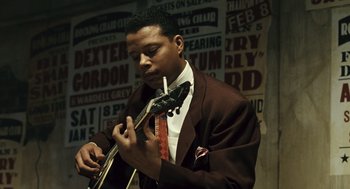 Movie still from “Ray” (2004), directed by Taylor Hackford – A man in a suit and tie holding a guitar; Close Up shot, Low angle