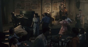 Movie still from “Ray” (2004), directed by Taylor Hackford – A group of people standing in a room with musical instruments; Extreme Wide shot, High angle
