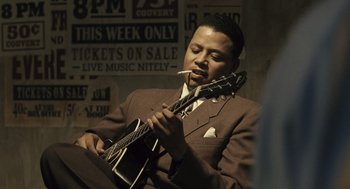Movie still from “Ray” (2004), directed by Taylor Hackford – A man in a suit and tie playing a guitar; Close Up shot, Low angle