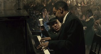Movie still from “Ray” (2004), directed by Taylor Hackford – Two men are playing piano in front of a crowd; Medium shot, Low angle