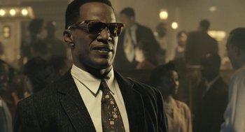 Movie still from “Ray” (2004), directed by Taylor Hackford – A man in a suit and tie wearing sunglasses; Close Up shot, Low angle