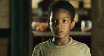 Movie still from “Ray” (2004), directed by Taylor Hackford – A young black boy is looking at the camera; Close Up shot, Over the shoulder angle