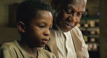 An older man and a young boy looking at each other