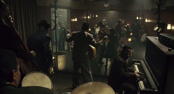 Movie still from “Ray” (2004), directed by Taylor Hackford – A group of people in a room with musical instruments; Wide shot, High angle