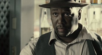 Movie still from “Ray” (2004), directed by Taylor Hackford – A man wearing a hat and a striped shirt; Close Up shot, Over the shoulder angle