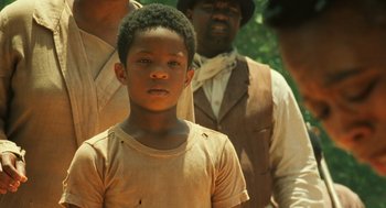 Movie still from “Ray” (2004), directed by Taylor Hackford – A young boy standing in front of a group of men; Close Up shot, Over the shoulder angle