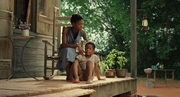Movie still from “Ray” (2004), directed by Taylor Hackford – A woman sitting on a porch next to a child; Medium shot, Over the shoulder angle