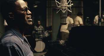 Movie still from “Ray” (2004), directed by Taylor Hackford – A man in a recording studio singing into a microphone; Close Up shot, Over the shoulder angle