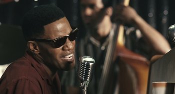 Movie still from “Ray” (2004), directed by Taylor Hackford – A person singing on a microphone; Close Up shot, Over the shoulder angle
