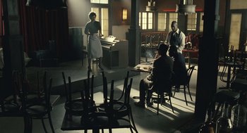 Movie still from “Ray” (2004), directed by Taylor Hackford – A group of people sitting at a table in a room; Wide shot, High angle