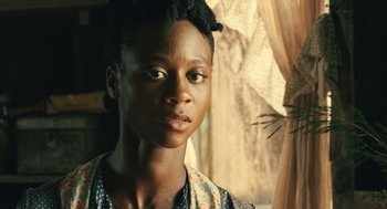 Movie still from “Ray” (2004), directed by Taylor Hackford – A young woman with short black hair is looking at the camera; Close Up shot, Over the shoulder angle