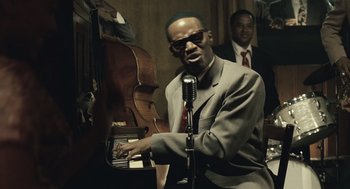 Movie still from “Ray” (2004), directed by Taylor Hackford – A man in a suit and tie playing a piano; Close Up shot, Over the shoulder angle