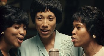 Movie still from “Ray” (2004), directed by Taylor Hackford – A woman with a microphone and two other women; Close Up shot, High angle