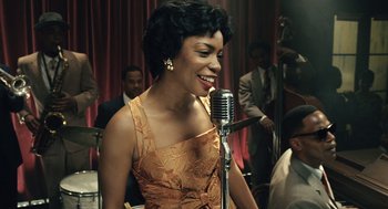 Movie still from “Ray” (2004), directed by Taylor Hackford – A woman in a dress is singing into a microphone; Close Up shot, High angle