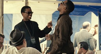 Two men are laughing together at an outdoor event