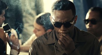 Movie still from “Ray” (2004), directed by Taylor Hackford – A man smoking a cigarette while wearing sunglasses; Close Up shot, Low angle