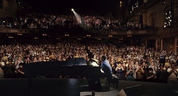 Movie still from “Ray” (2004), directed by Taylor Hackford – A man sitting at a piano in front of an audience; Extreme Wide shot, High angle