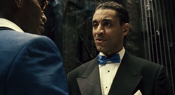 Movie still from “Ray” (2004), directed by Taylor Hackford – A man in a suit and bow tie talking to another man in a suit and bow tie; Close Up shot, Low angle
