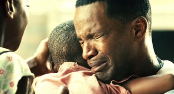 Movie still from “Ray” (2004), directed by Taylor Hackford – An older man holding a young child in his arms; Close Up shot, Over the shoulder angle