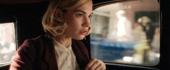 Movie still from “Rebecca” (2020), directed by Ben Wheatley – A woman sitting in a car looking out the window; Close Up shot, Over the shoulder angle