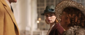 Movie still from “Rebecca” (2020), directed by Ben Wheatley – A woman wearing a hat with a bow on it's brim; Close Up shot, Over the shoulder angle