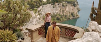 Movie still from “Rebecca” (2020), directed by Ben Wheatley – A man and a woman standing on a balcony; Wide shot, High angle