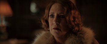 Movie still from “Rebecca” (2020), directed by Ben Wheatley – An older woman wearing a fur coat looking at the camera; Close Up shot, Over the shoulder angle