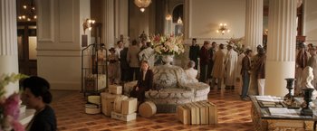 Movie still from “Rebecca” (2020), directed by Ben Wheatley – A group of people standing in a room with suitcases; Wide shot, High angle