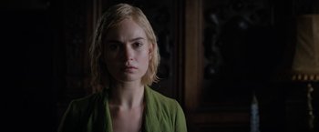 Movie still from “Rebecca” (2020), directed by Ben Wheatley – A woman with blonde hair wearing a green shirt; Close Up shot, Over the shoulder angle