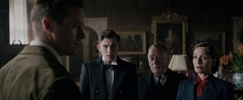 Movie still from “Rebecca” (2020), directed by Ben Wheatley – Two men in suits standing next to each other in front of a mirror; Medium shot, Over the shoulder angle