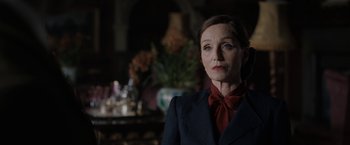 Movie still from “Rebecca” (2020), directed by Ben Wheatley – A woman wearing a suit and a red neck tie; Close Up shot, Over the shoulder angle