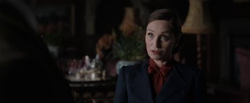 Movie still from “Rebecca” (2020), directed by Ben Wheatley – A woman wearing a suit and a red neck tie; Close Up shot, Over the shoulder angle