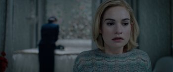 Movie still from “Rebecca” (2020), directed by Ben Wheatley – A person with short blonde hair; Close Up shot, Over the shoulder angle