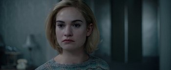 Movie still from “Rebecca” (2020), directed by Ben Wheatley – A young woman with blonde hair and a sweater; Close Up shot, Over the shoulder angle